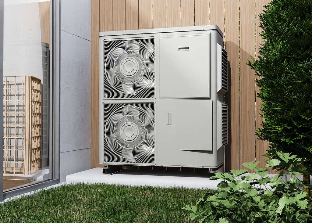 High-efficiency heat pump outdoor unit on a modern home, energy efficient climate control system.